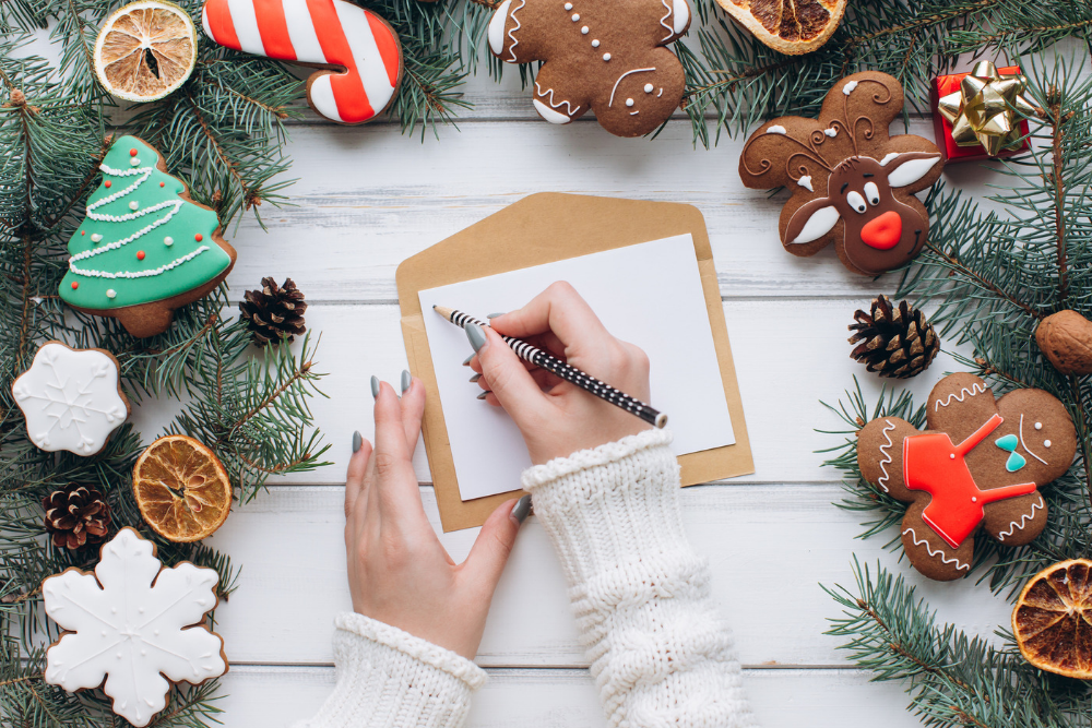 Eine Weihnachtskarte wird mit einem Bleistift beschrieben. 
